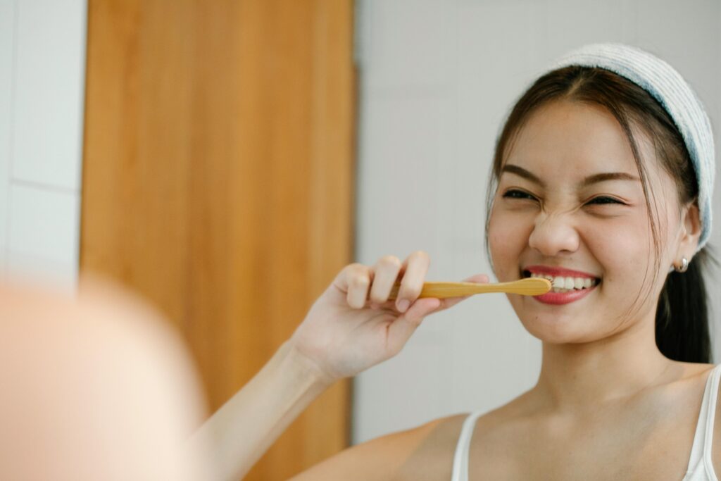 A woman brushing her teeth to avoid bad breath